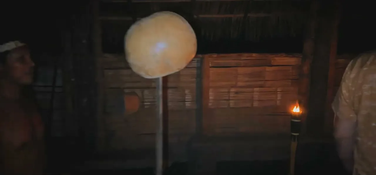 A torch-lit hut at night set up for an ayahuasca ceremony in the Amazon