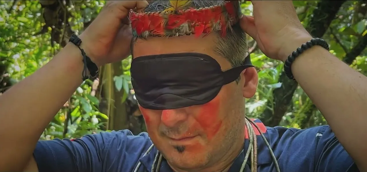 Sorin blindfolded and face-painted, preparing to throw a blow-dart at a world map