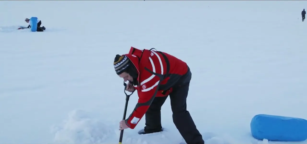 Sorin digging a trench in the snow to sleep in while camping on the Antarctic Peninsula
