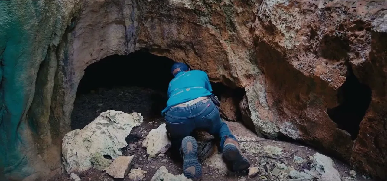 Sorin exploring a cave entrance on the rocky coast of Barbuda