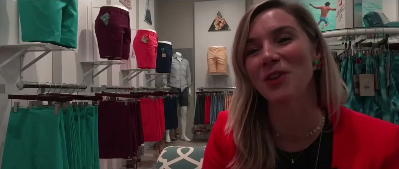 Rebecca of TABS in a shop with racks of colourful Bermuda shorts