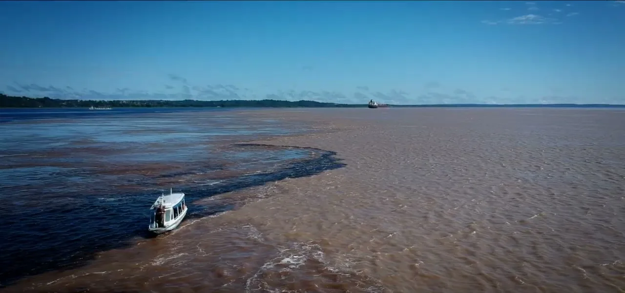 A boat traveling on a wide river in the Amazon near Manaus, Brazil