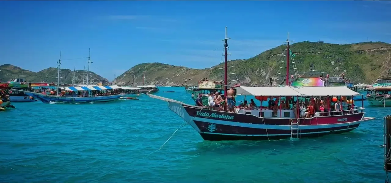 A boat party on bright blue water off the coast near Arraial do Cabo, Brazil