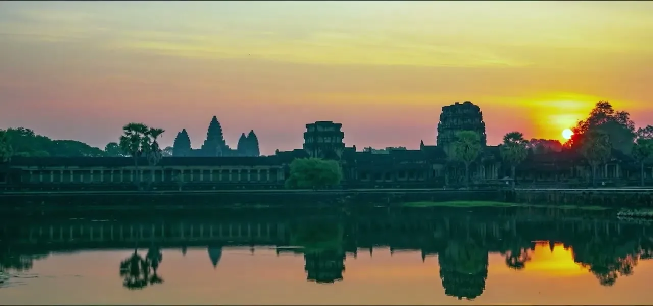 Angkor Wat silhouetted at sunrise, reflected in the moat, Cambodia