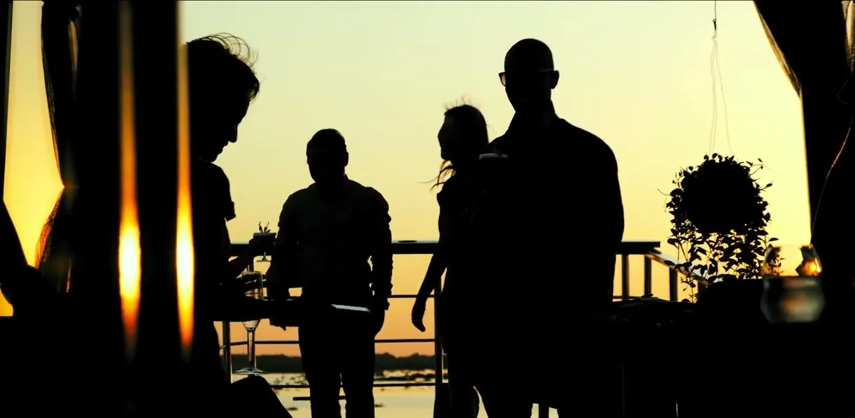 Guests at sunset aboard the Samsara cruise on the water near Tonle Sap, Cambodia