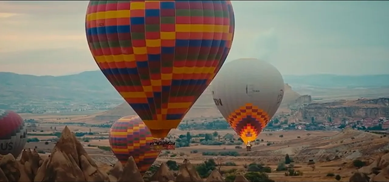 Colourful hot-air balloons inflating and lifting off over the Cappadocian valley