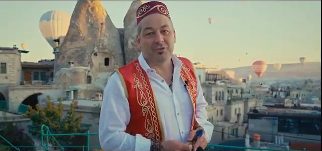 Sorin in traditional Turkish dress throwing a dart, with balloons behind him