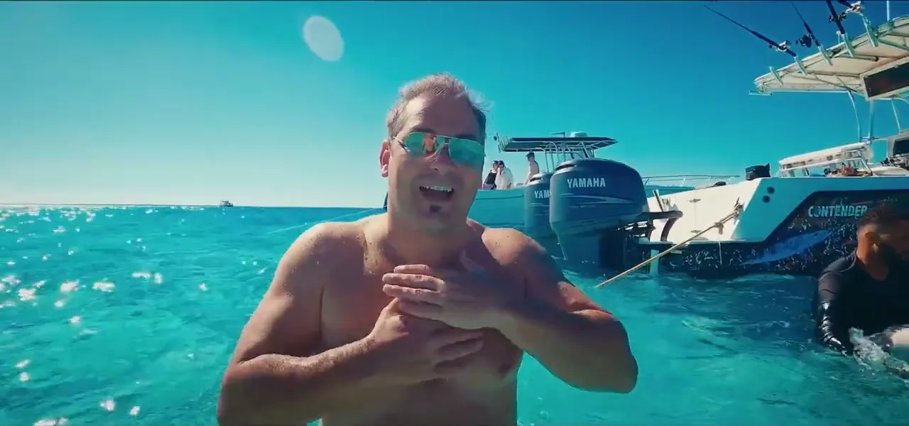 Sorin in the water surrounded by stingrays at Stingray City, Grand Cayman