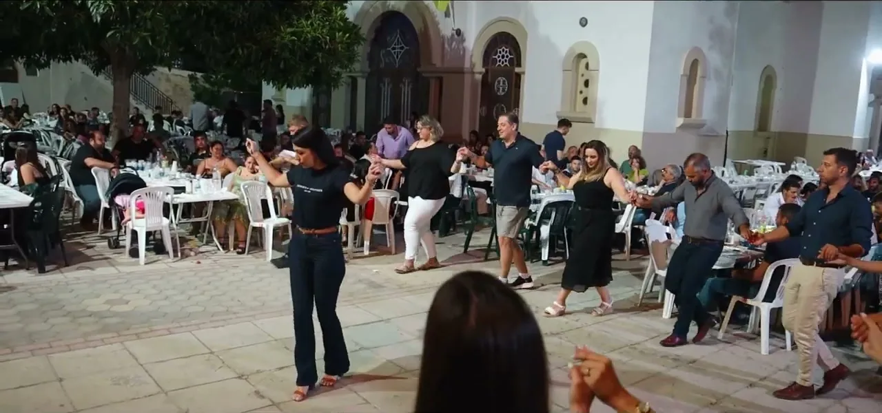 Villagers dancing in circles at a Cretan feast at night