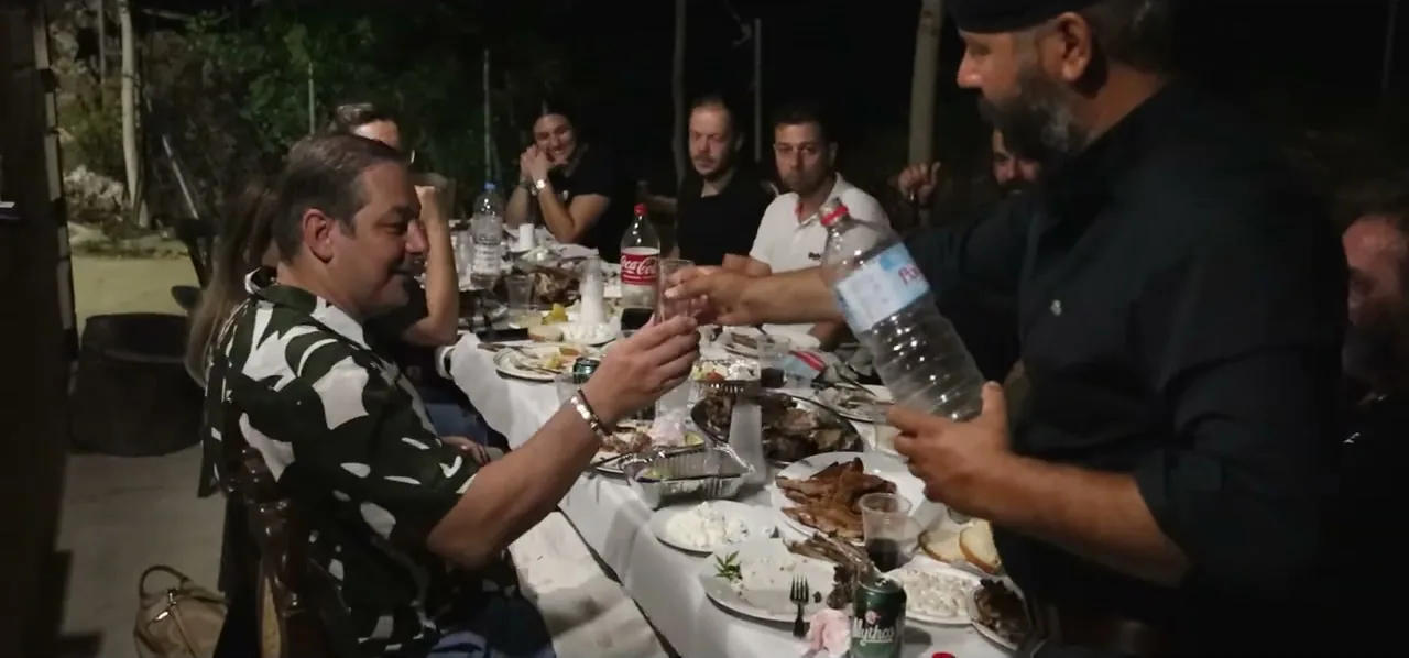 Cretans sharing a single glass of wine around a table as a sign of hospitality