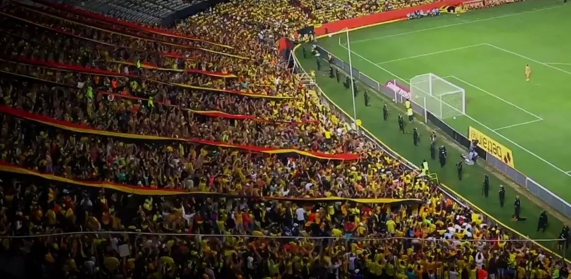 A packed stadium of yellow-clad Barcelona Sporting Club fans in Guayaquil, Ecuador