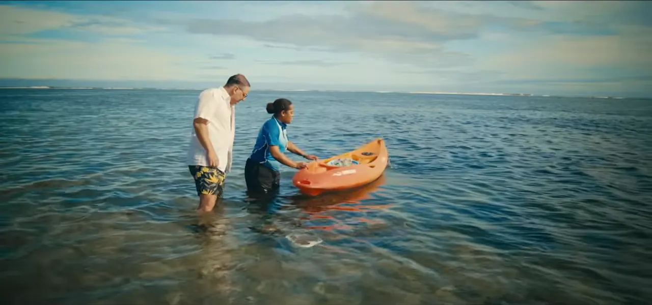 Sorin and an environmental officer planting coral in shallow water in Fiji