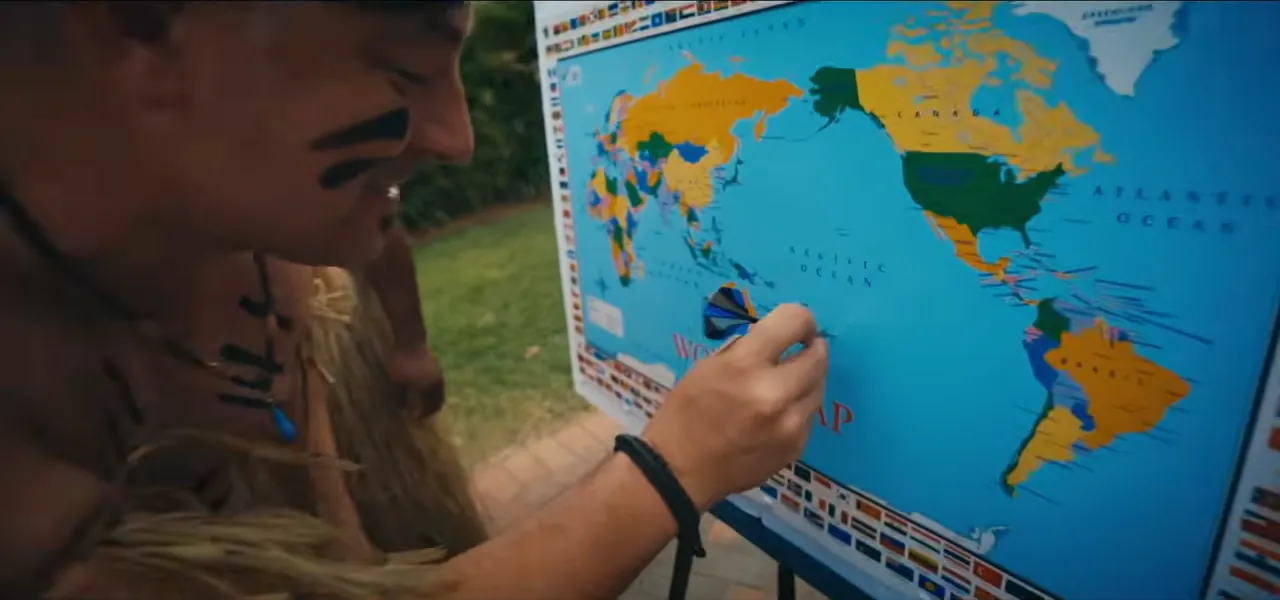 Sorin, painted and dressed as a Fijian warrior, throwing a dart at a world map