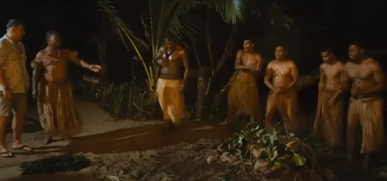 Fijian firewalkers in grass skirts gathered around the fire pit at night