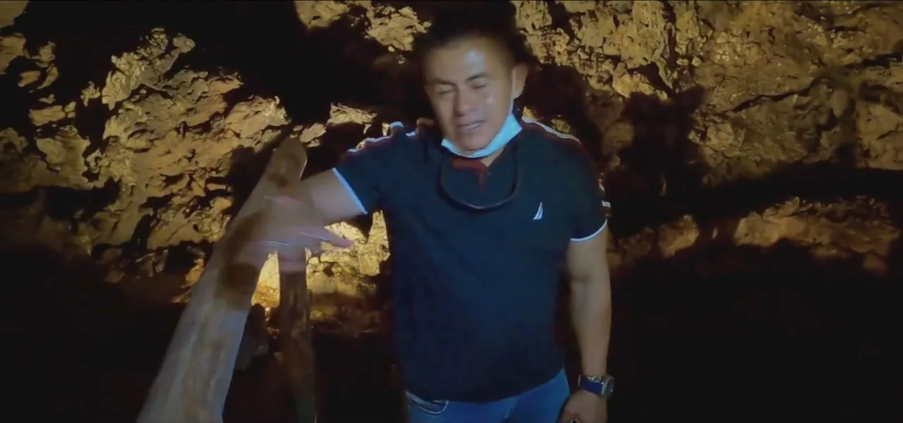 A person exploring a lava tunnel beneath the Galápagos highlands