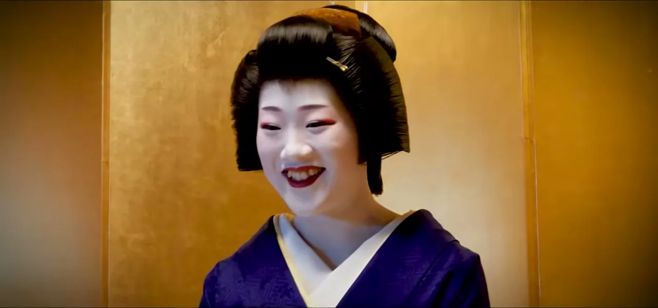 Tomitae, a geiko in full white makeup and formal kimono, in a Kyoto tea house