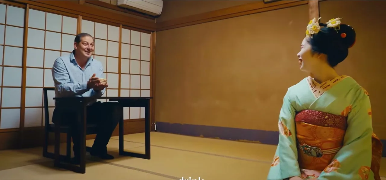 Sorin seated at a low table watching a maiko perform during the private evening