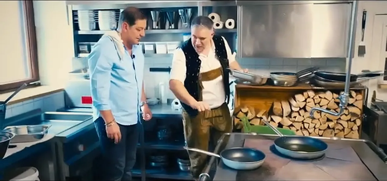 Sorin learning to cook schnitzel with a chef at the Röhrl restaurant