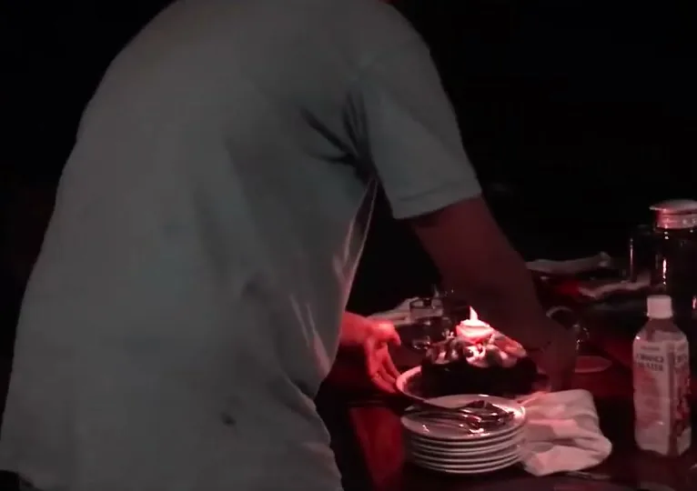 A birthday cake being lit aboard the Al Iikai, celebrated by the Indonesian crew