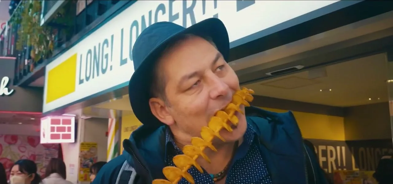 Sorin eating spiral potato street food in the Harajuku district of Tokyo