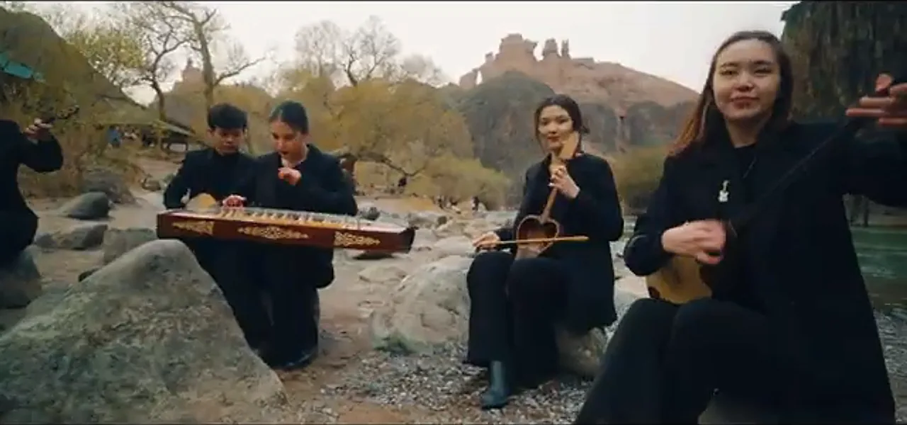 Kazakh musicians playing traditional instruments by a river in Charyn Canyon
