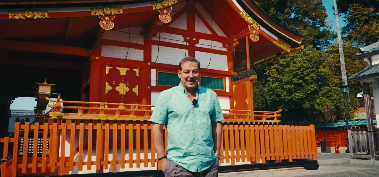 Sorin standing before the vermilion buildings of Fushimi Inari Taisha shrine in Kyoto