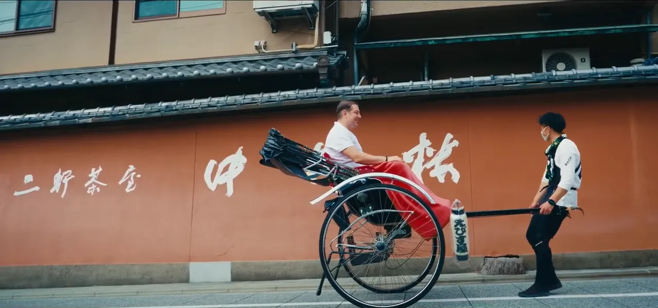 A traditional red rickshaw on a preserved old street in Kyoto
