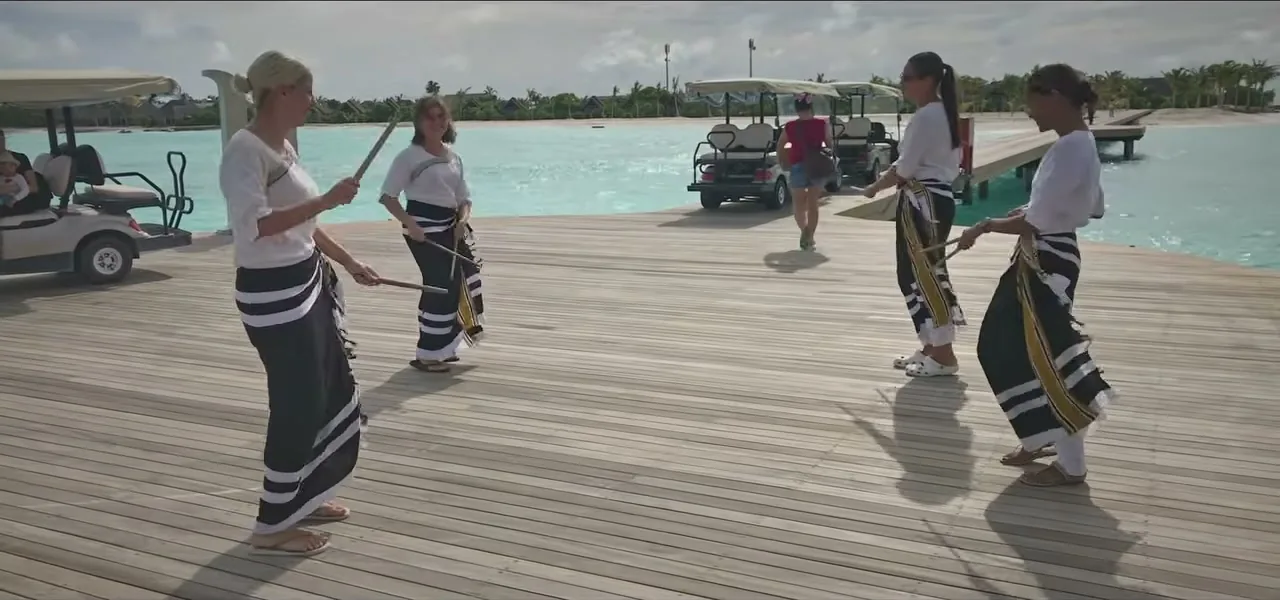 A traditional Maldivian welcome ceremony with drummers on a resort jetty