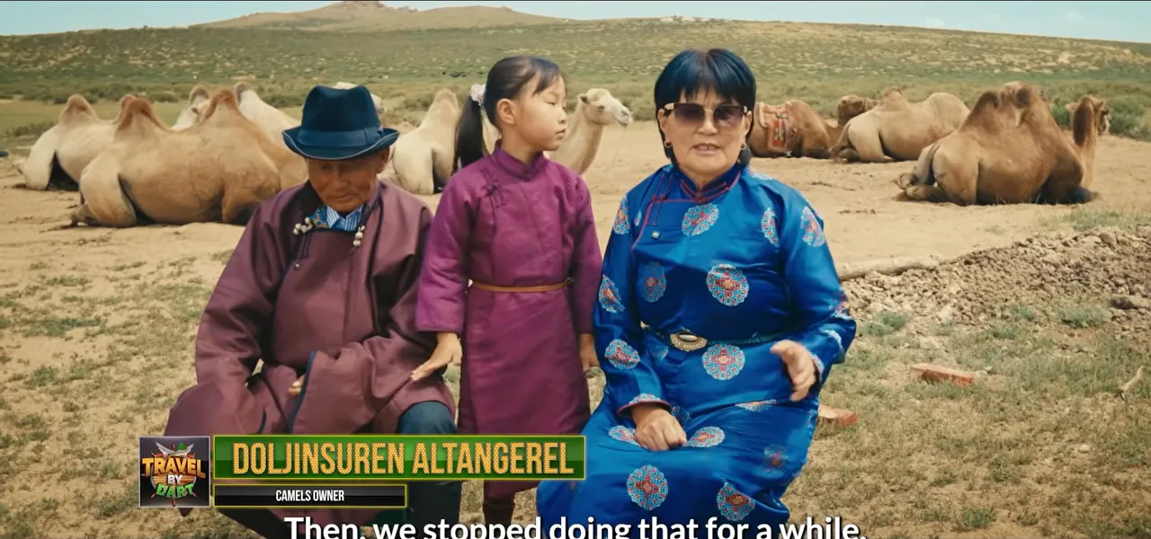A Mongolian family in traditional dress standing before their Bactrian camels