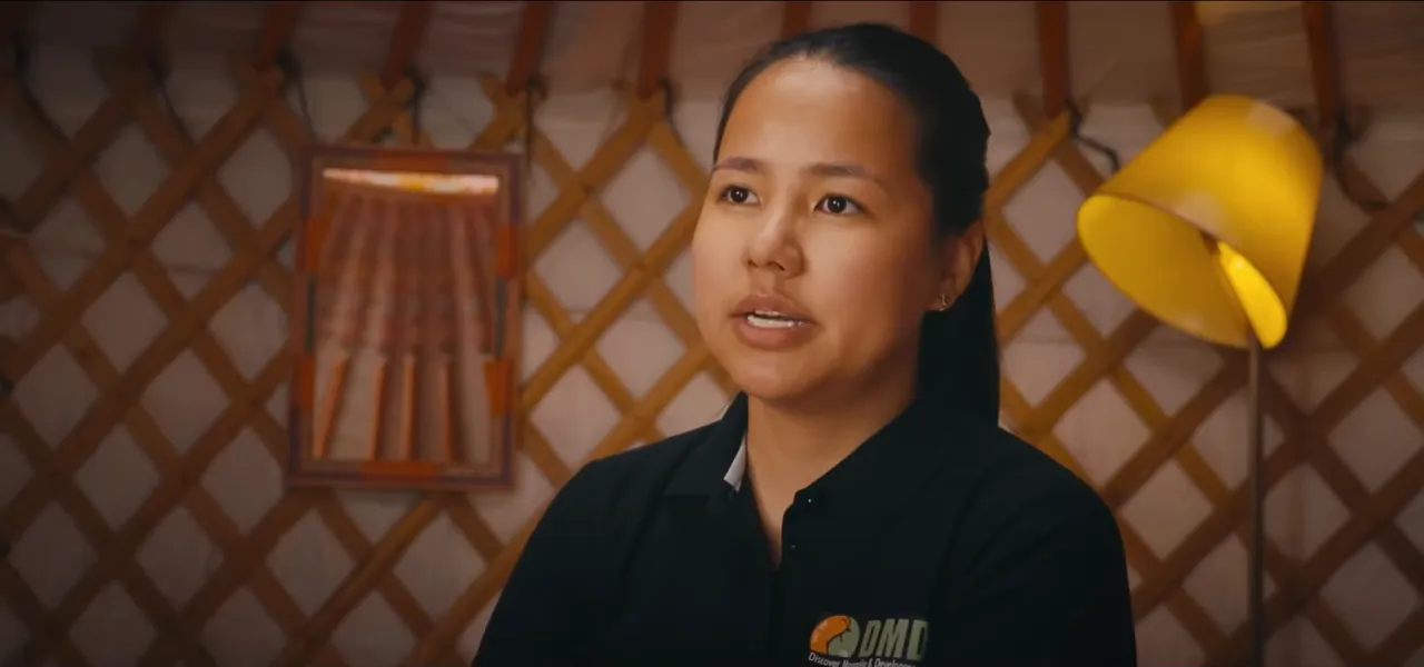 Nara, a guide from DMD Mongolia, speaking inside a traditional ger