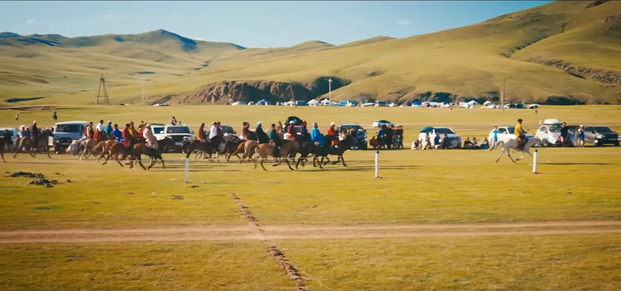 Crowds, gers and horse riders gathered on the steppe for a local Naadam festival