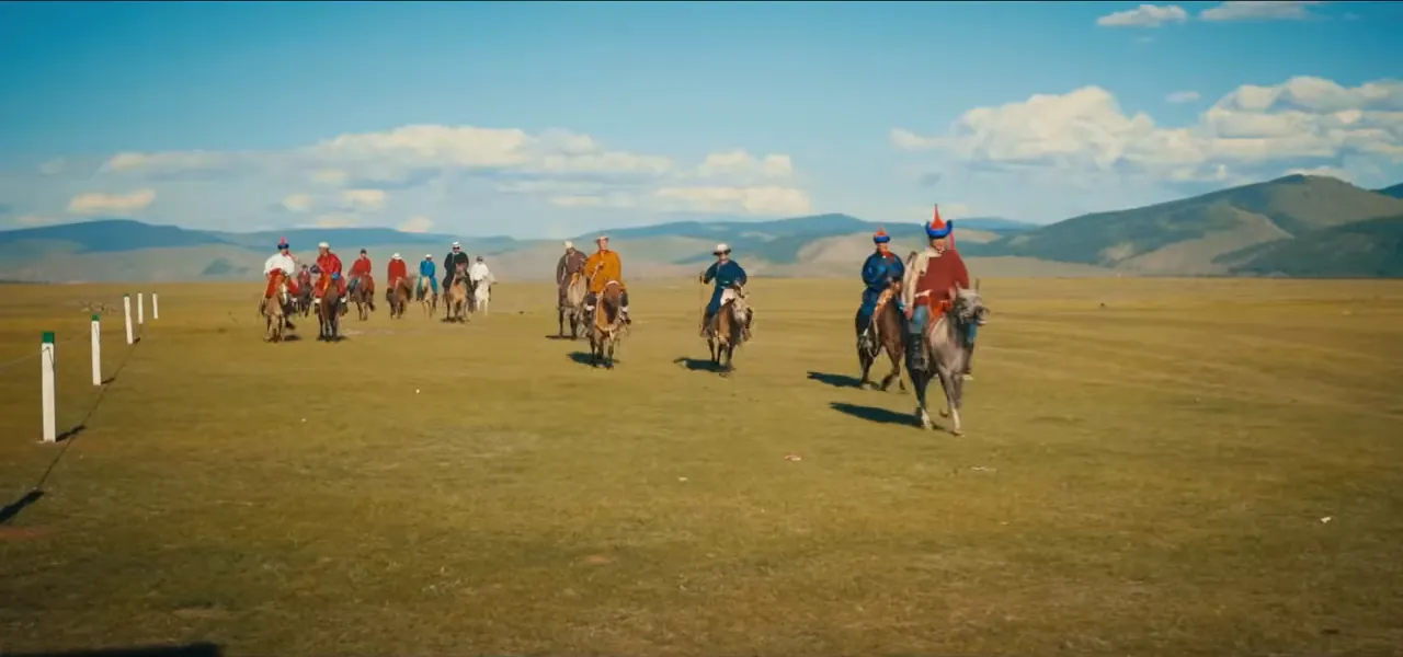 Horse riders competing across the open steppe at a Mongolian Naadam festival