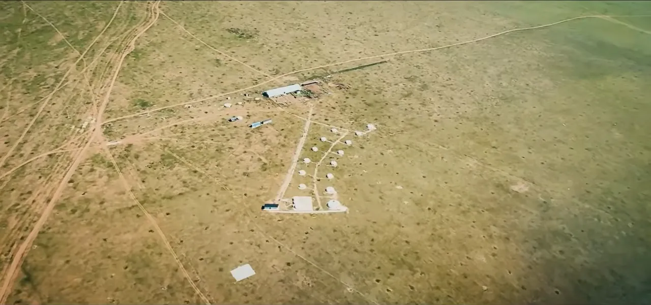 A lone nomadic settlement on the vast green Mongolian steppe, seen from the air
