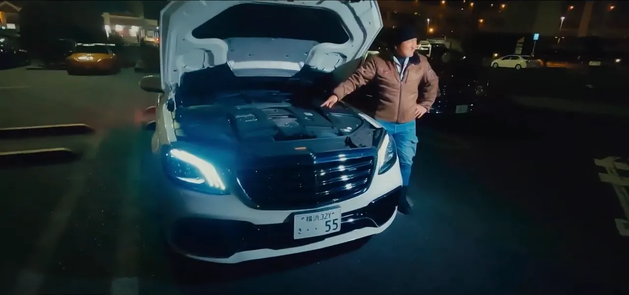 A customised car with its hood up at a night car meet at Daikoku parking area, Japan