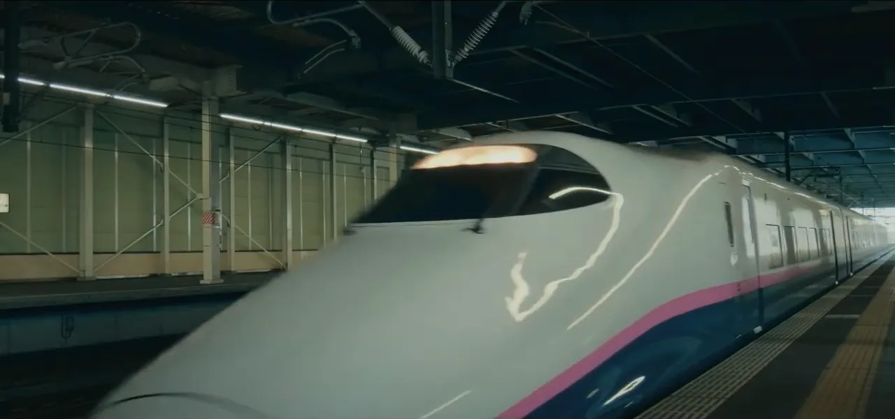 A white shinkansen bullet train at a station platform in Japan