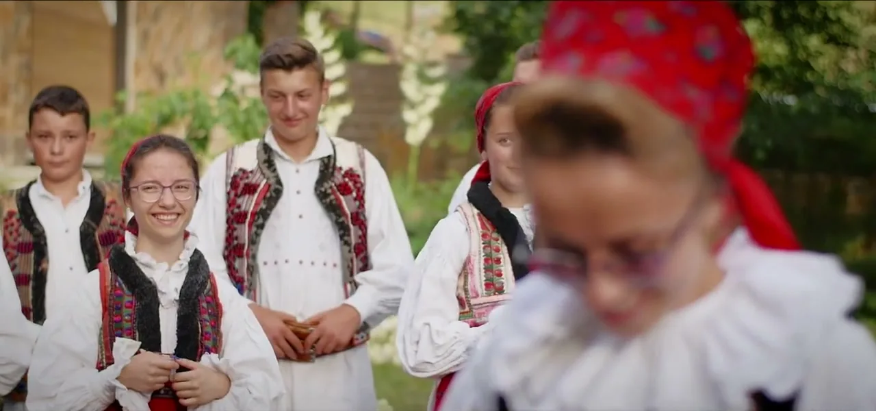 Young Romanian folk dancers in traditional embroidered costumes in Budureasa, Romania