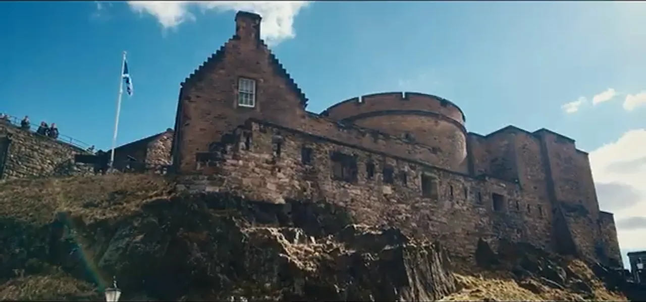 Edinburgh Castle's stone battlements perched on Castle Rock beneath a blue sky