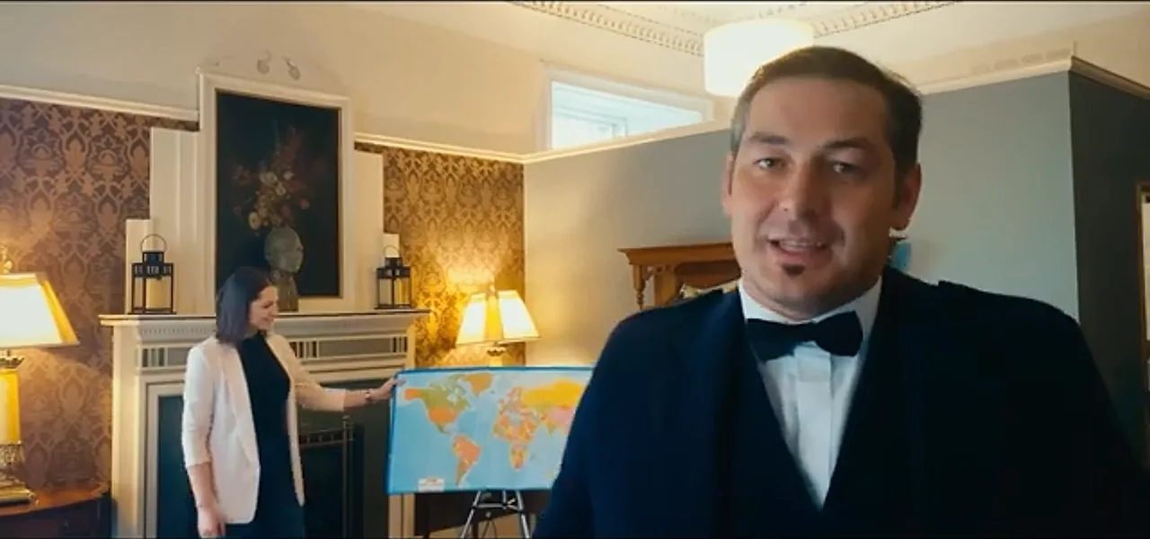 Sorin in full Highland dress preparing to throw the dart at a world map in the hotel