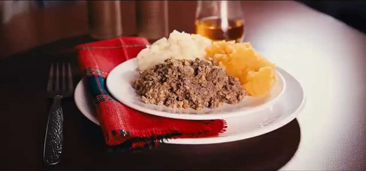 A plate of haggis with mashed turnip and potato, and a glass of whisky