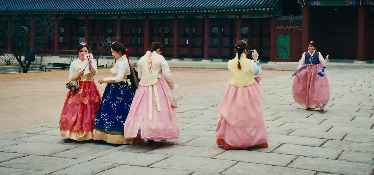 Women in colourful hanbok walking through a palace courtyard in Seoul