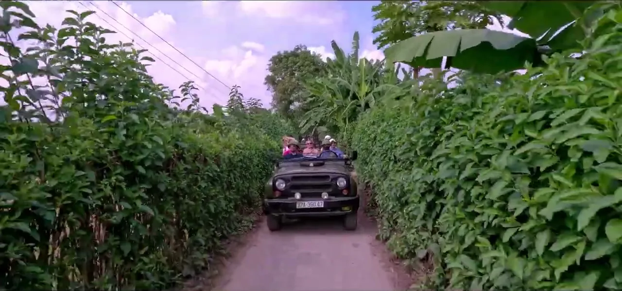 A restored Soviet-era army jeep on a tour along a green back lane near Hanoi, Vietnam